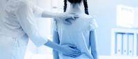 Medical provider examining a child's spine